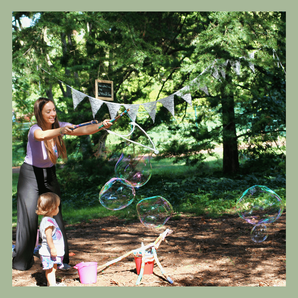 atelier sur l'air et le ciel avec des bulles géantes. moment de complicité entre les tout-petits et les parents.
Les moments bulles géantes ont été un vrai déclic pour moi. Je m’attendais à ce que les enfants s’éclatent et en aient plein les yeux mais je me suis rendue compte à ce moment à quel point les parents ont besoin d’enchantement, de rêves, de souffle et de jeux, eux aussi. 
J’ai vu les parents rire, recommencer encore et encore, rechigner à partager les bâtons et faire des colères quand les enfants renversaient leur seau avec le liquide bulles . Bref, je les ai vu redevenir de vrais gosses et je pense que ça a fait du bien!
Je vois bien dans mon quotidien à quel point en tant que parent, on dispose de si peu d’espace pour laisser de la place à notre propre enfant intérieur, celui qui a envie de jouer, flâner, s’émerveiller et ne rien gérer l’espace de quelques instants. 
Et depuis ce jour, je mets en place à chaque atelier un moment destiné aux parents pour que tout le monde ait un temps pour s’amuser et déconnecter un peu. 
