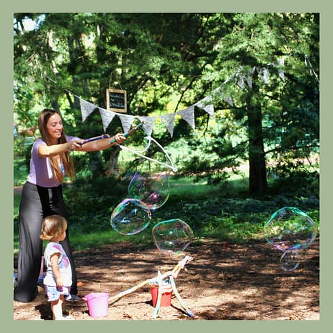 atelier sur l'air et le ciel avec des bulles géantes. moment de complicité entre les tout-petits et les parents.
Les moments bulles géantes ont été un vrai déclic pour moi. Je m’attendais à ce que les enfants s’éclatent et en aient plein les yeux mais je me suis rendue compte à ce moment à quel point les parents ont besoin d’enchantement, de rêves, de souffle et de jeux, eux aussi. 
J’ai vu les parents rire, recommencer encore et encore, rechigner à partager les bâtons et faire des colères quand les enfants renversaient leur seau avec le liquide bulles . Bref, je les ai vu redevenir de vrais gosses et je pense que ça a fait du bien!
Je vois bien dans mon quotidien à quel point en tant que parent, on dispose de si peu d’espace pour laisser de la place à notre propre enfant intérieur, celui qui a envie de jouer, flâner, s’émerveiller et ne rien gérer l’espace de quelques instants. 
Et depuis ce jour, je mets en place à chaque atelier un moment destiné aux parents pour que tout le monde ait un temps pour s’amuser et déconnecter un peu. 
